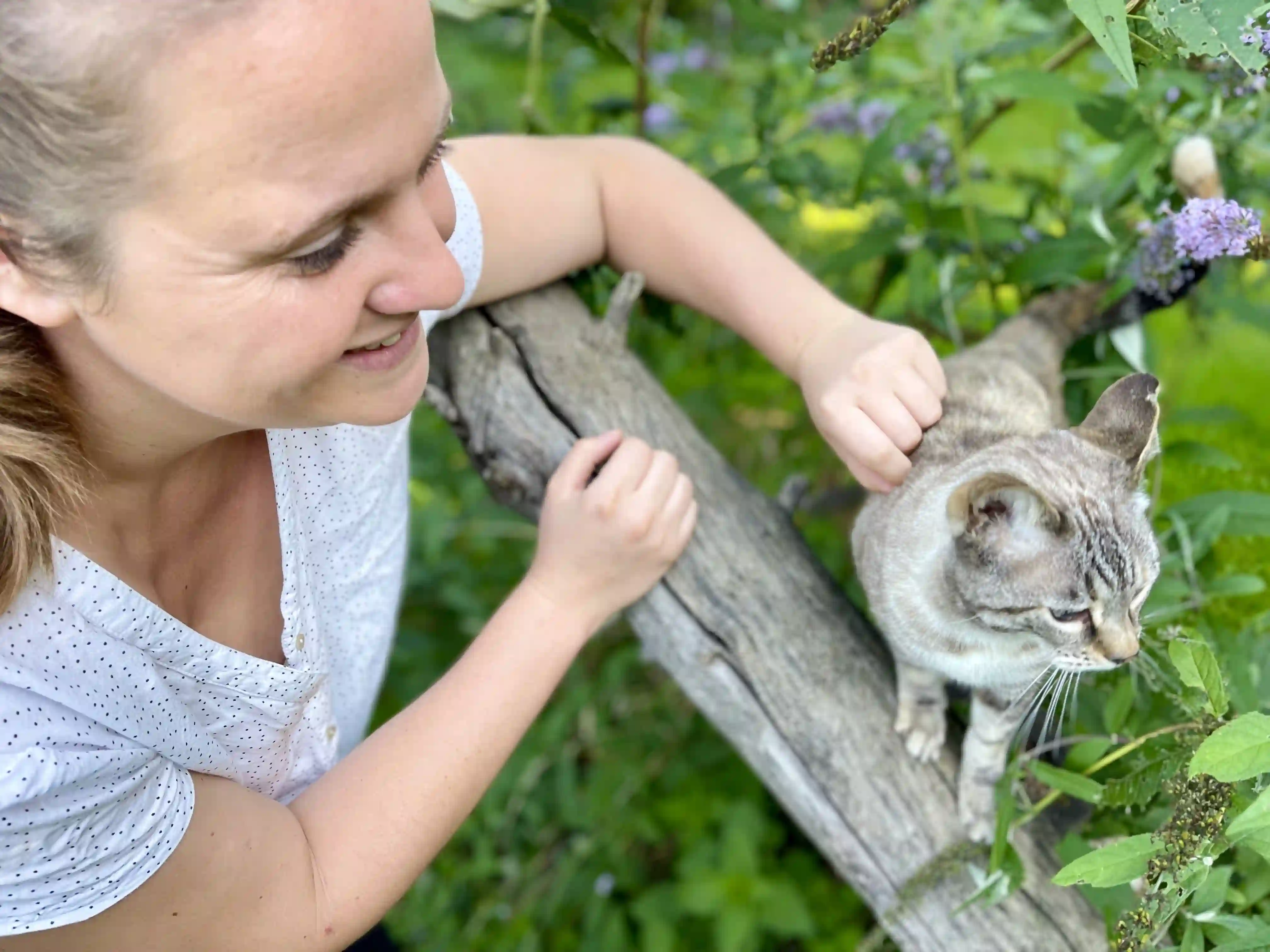 Tierärztin Nadine Küpper streichelt eine Katze im Garten